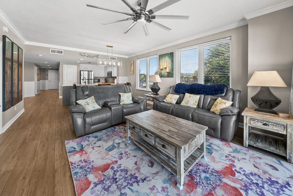 Relax in your spacious living room with plush leather seating and stylish decor, opening seamlessly to the modern kitchen.