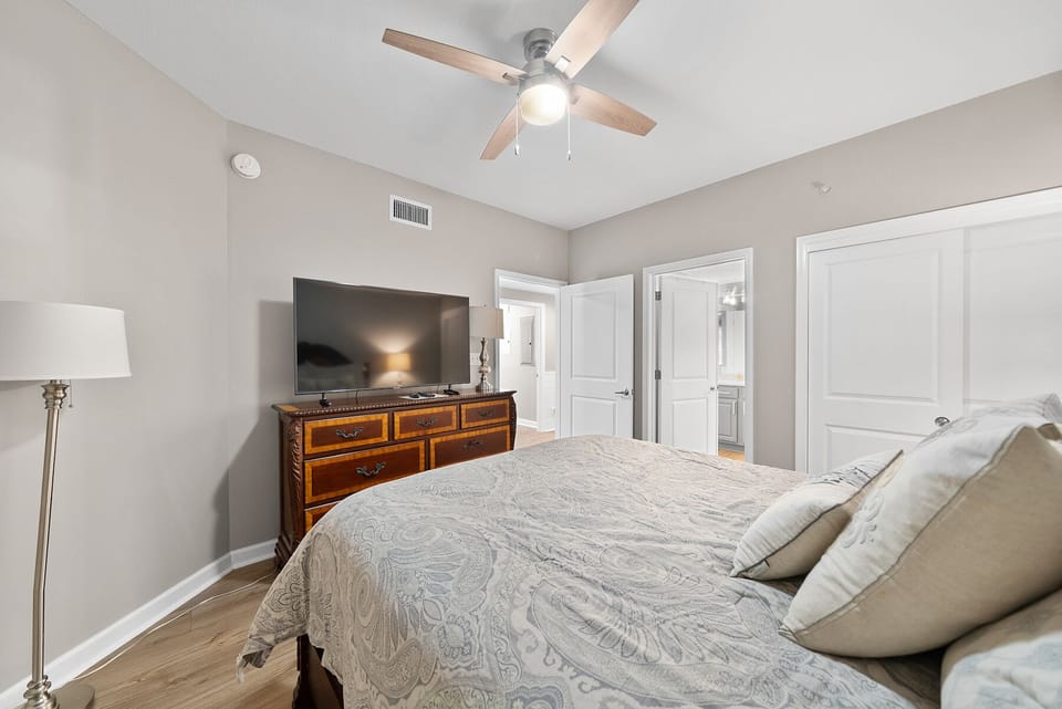 Drift into peaceful sleep surrounded by soft linens and warm wood tones, with gentle ceiling fan breezes.