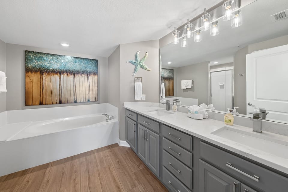 Soak in your spacious soaking tub beneath coastal artwork while preparing for the day at your dual vanity with ample counter space.