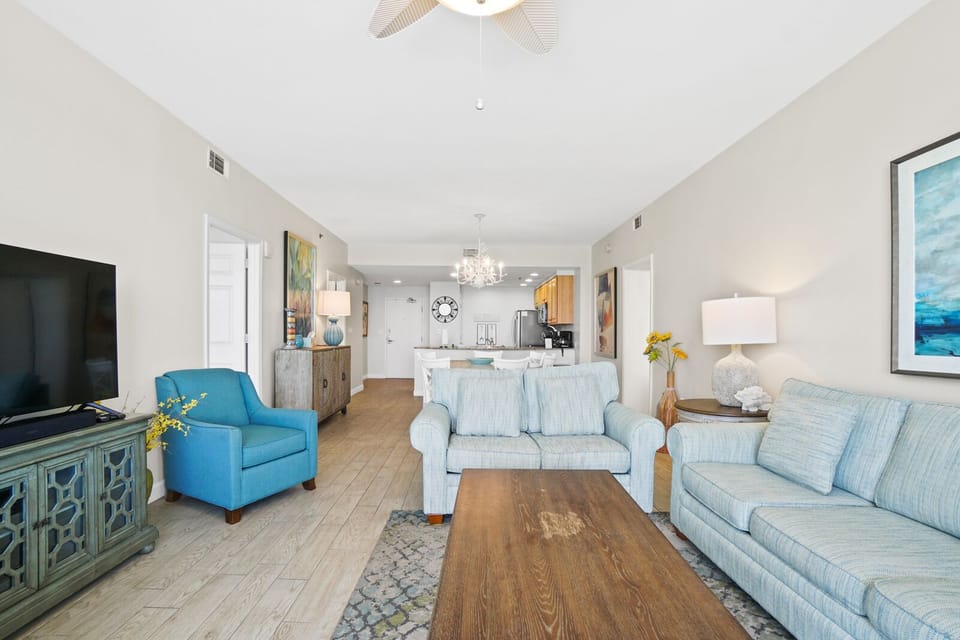 Relax in your bright, coastal-inspired living space with plush seating and open kitchen views for perfect vacation comfort.