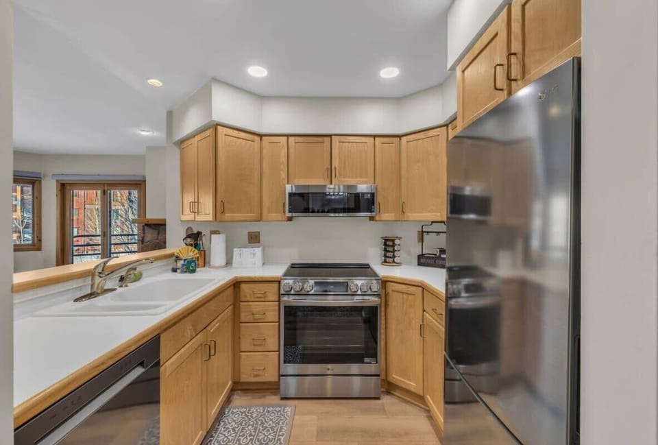 The fully-equipped kitchen overlooks the living room and dining area and includes two bar stools for additional seating.