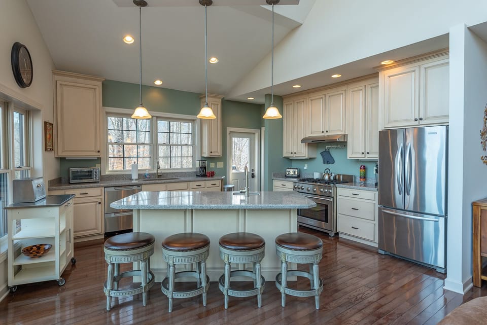 Gourmet kitchen with stainless appliances, gas range stove, dishwasher & standard drip-style coffeemaker.