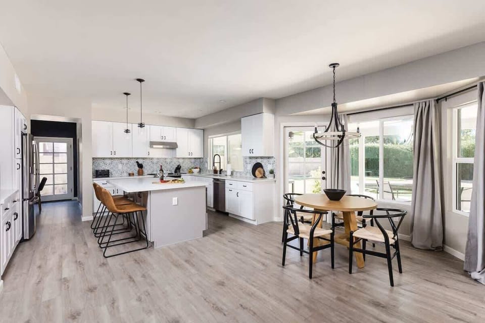 Fully equipped kitchen with stainless steel appliances, kitchen island with bar seating and dining area with seating for 4 guests.