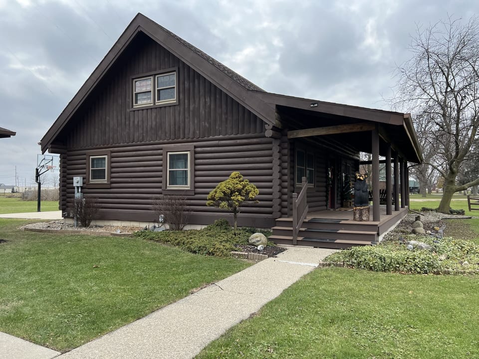 View when walking up to the log cabin. Side view of the home.