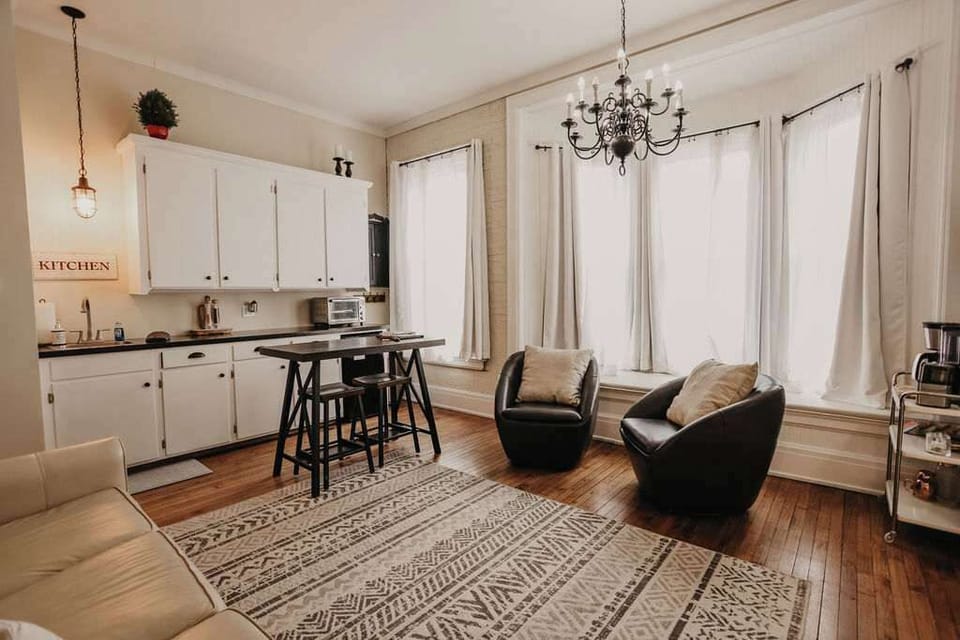 East Suite kitchen with large windows and bar‑height two‑seat table – bright, efficient Clare MI vacation rental space for coffee, quick meals, and remote work