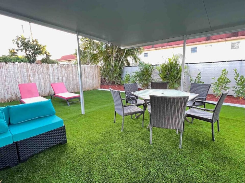 Patio furniture with plenty of seating and faux grass for a natural and clean setting
