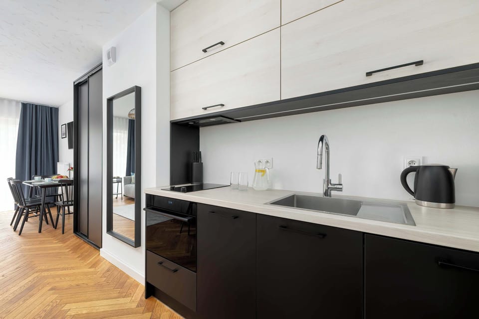 A modern kitchen with sleek cabinetry and essential appliances. The countertop is well-organized, offering a practical cooking space.