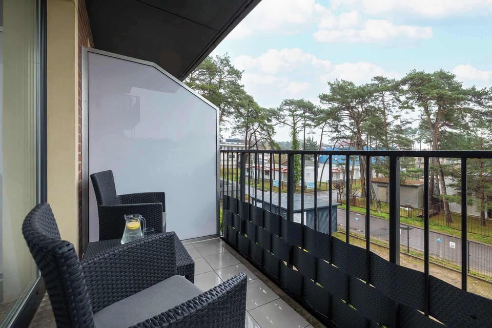 A balcony with chairs overlooking a lush green landscape. It's an inviting place to relax outdoors.