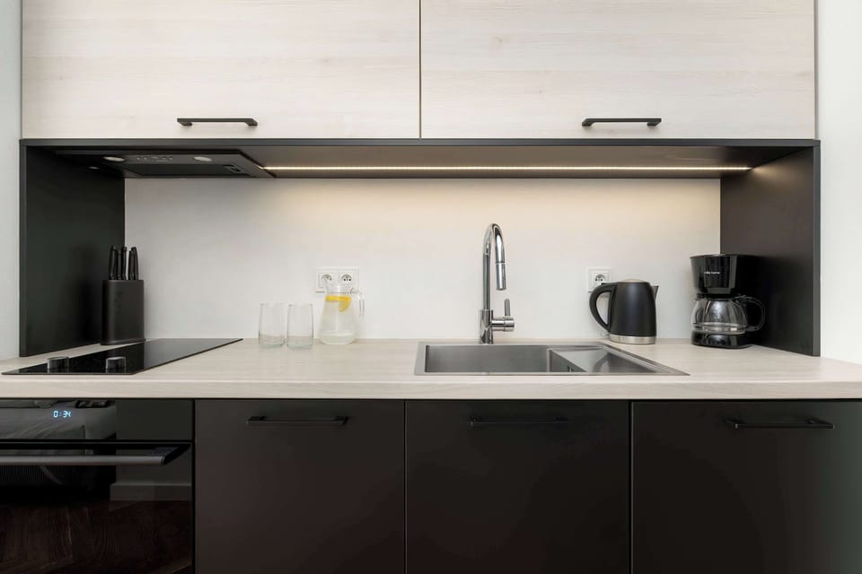 A modern kitchen with built-in appliances and upper cabinets. Clean surfaces provide ample working space.