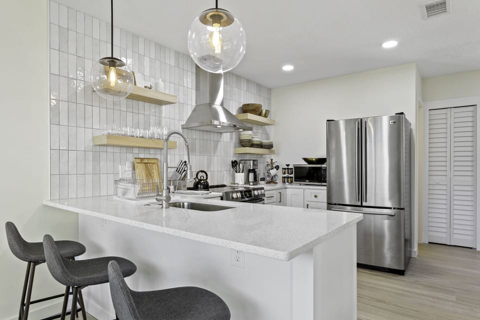 Well stocked kitchen with seating area at bar counter. 