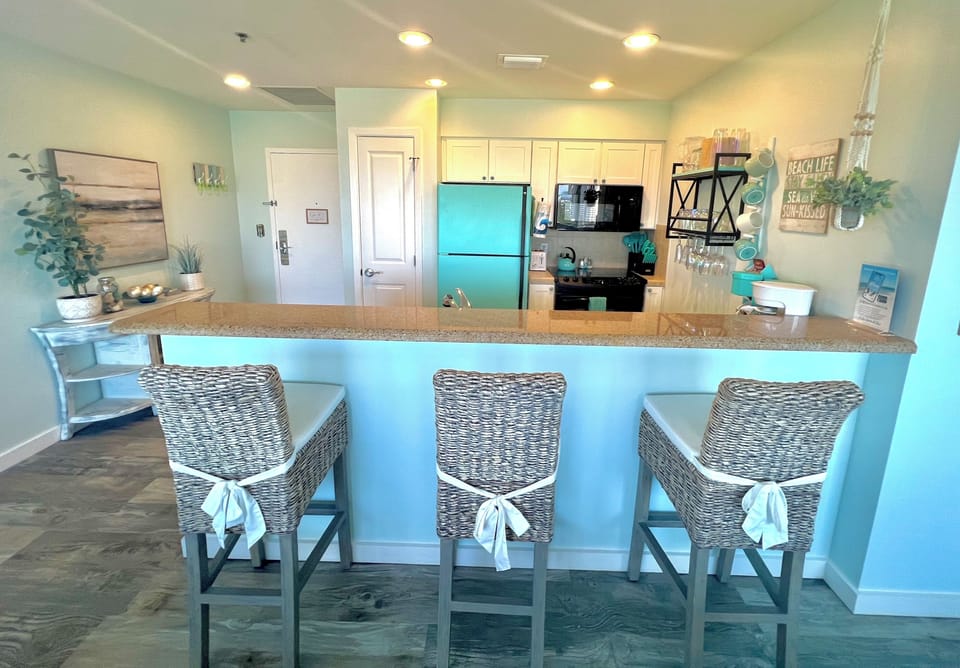 Gorgeous turquoise kitchen with 3 bar chairs. 