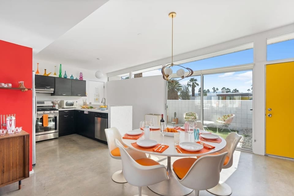 Classic Saarinen-style Tulip table and chairs with Knoll fabric cushions. Adrian Pearsall saucer-style lighting chandelier.