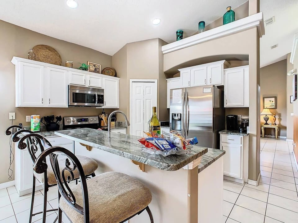 Fully equipped kitchen with breakfast bar, stainless steel appliances, and plenty of space to cook.