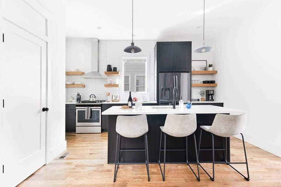 The open and airy kitchen features stainless steel appliances and a large island with seating for three.