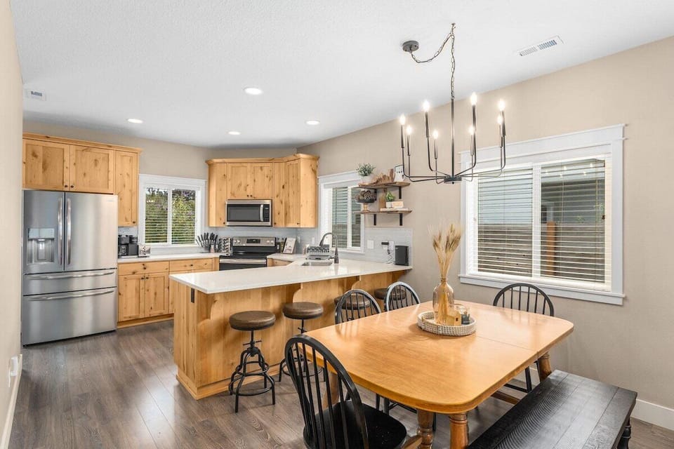 Seating for 10 and a fully stocked kitchen with appliances such as a refrigerator, oven, microwave, stove top, dishwasher, and Kuerig coffee maker.
