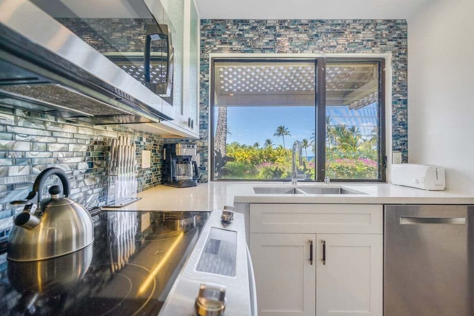 Cook in kitchens bright with mosaic tiles and palm views.