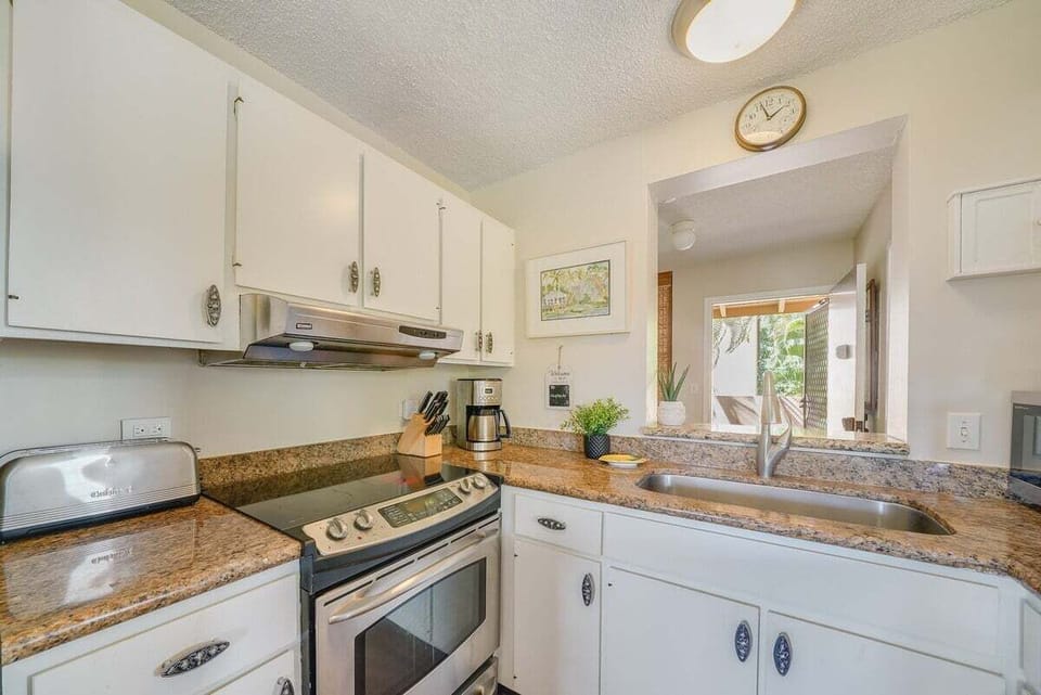 Sinks and stoves line the walls, clocks and framed art marking the rhythm of the room.