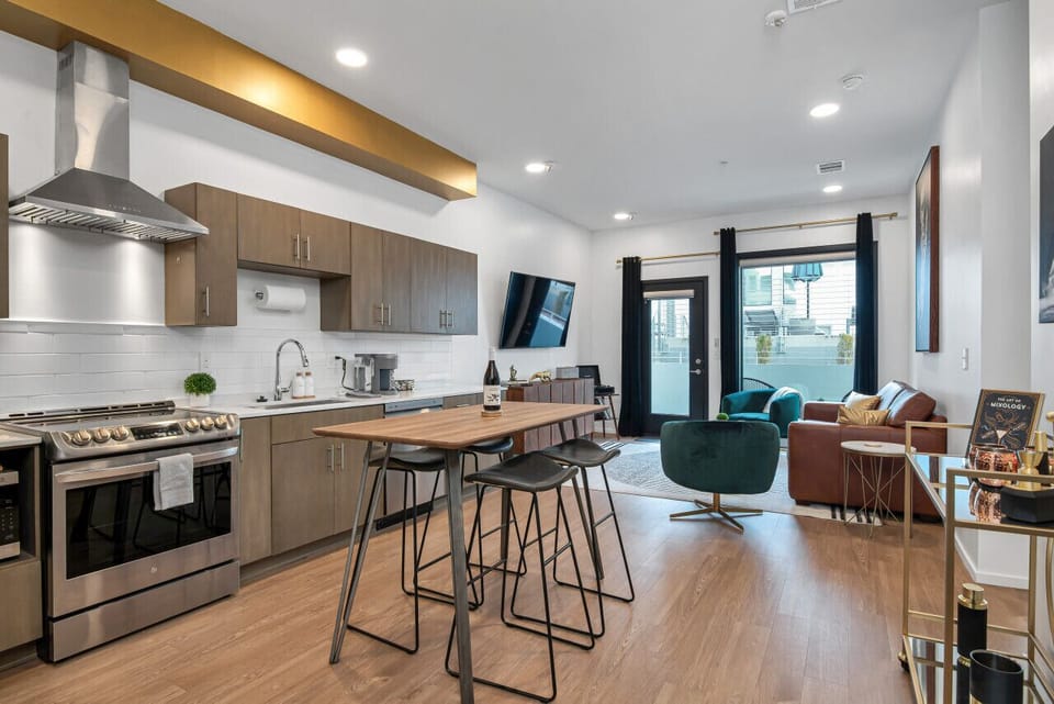 The well-equipped kitchen is fitted with ample cookware and a full suite of stainless steel appliances. Dining table with seating for four. Keurig coffee maker with Kcups and creamer.