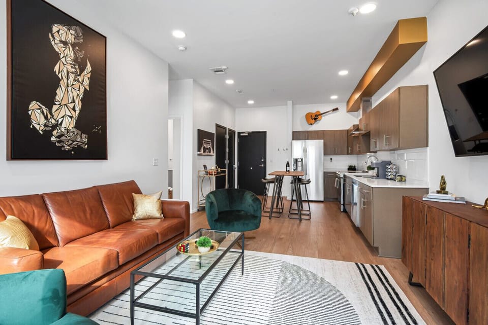 Cozy living room with 70 Smart TV. Comfortable leather couch that turns into a Queen sized pullout couch. Record player with vinyls albums. Open concept kitchen. Private patio off of the living room.