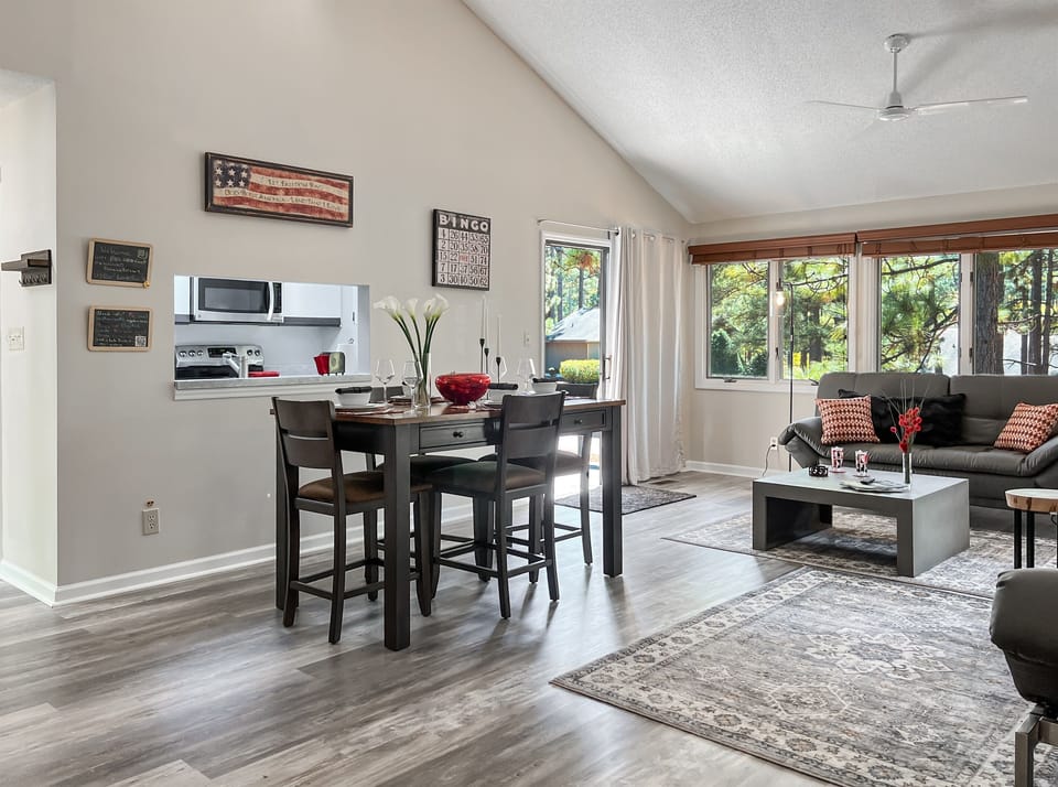 The open living/dining area is surrounded by views of gorgeous pines!