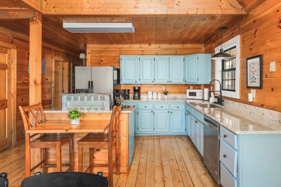 Fully-stocked kitchen with high-top seating for two and a large dining table with seating for 6