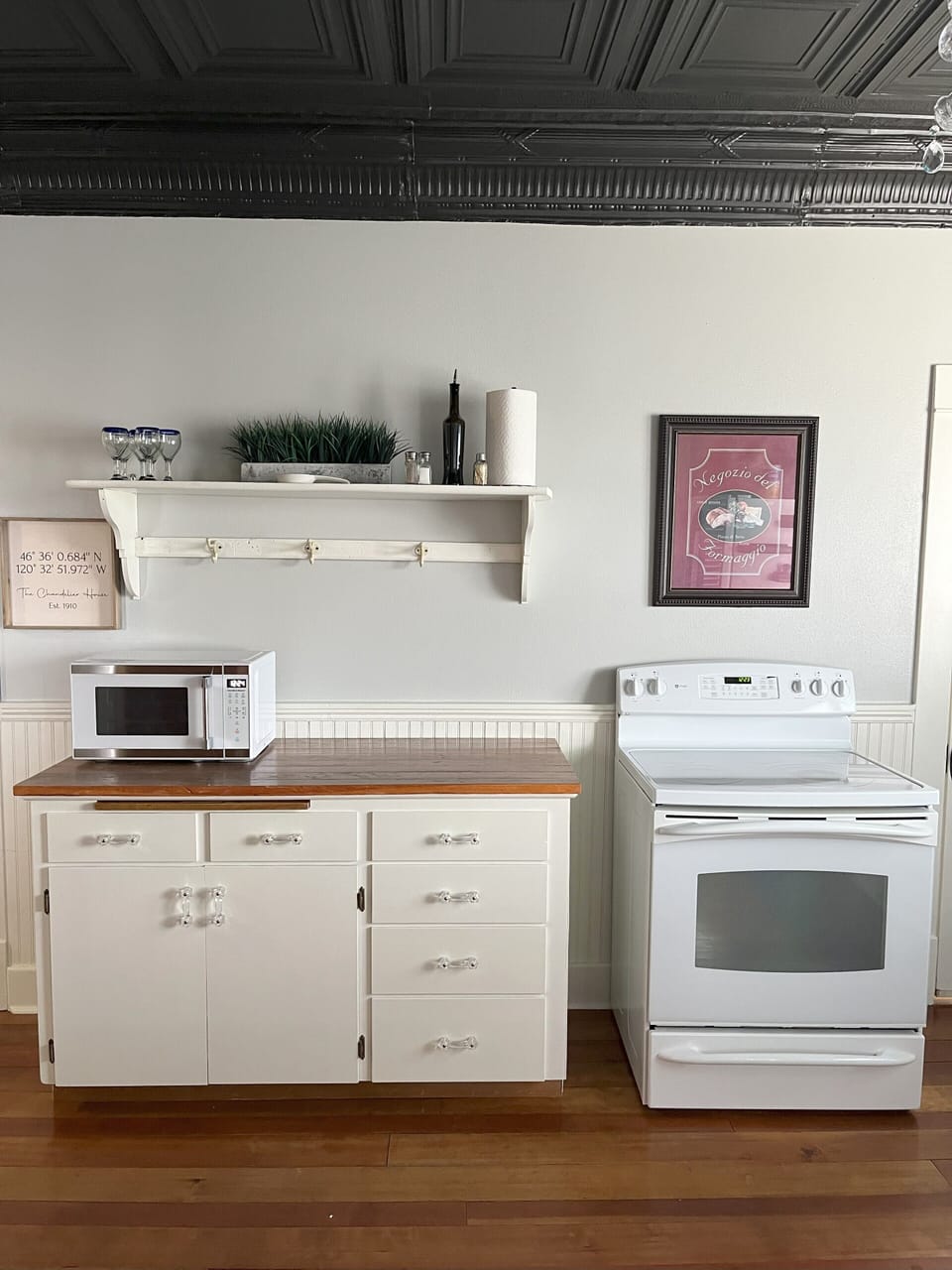 Microwave and electric stove/oven with food prep counter. 