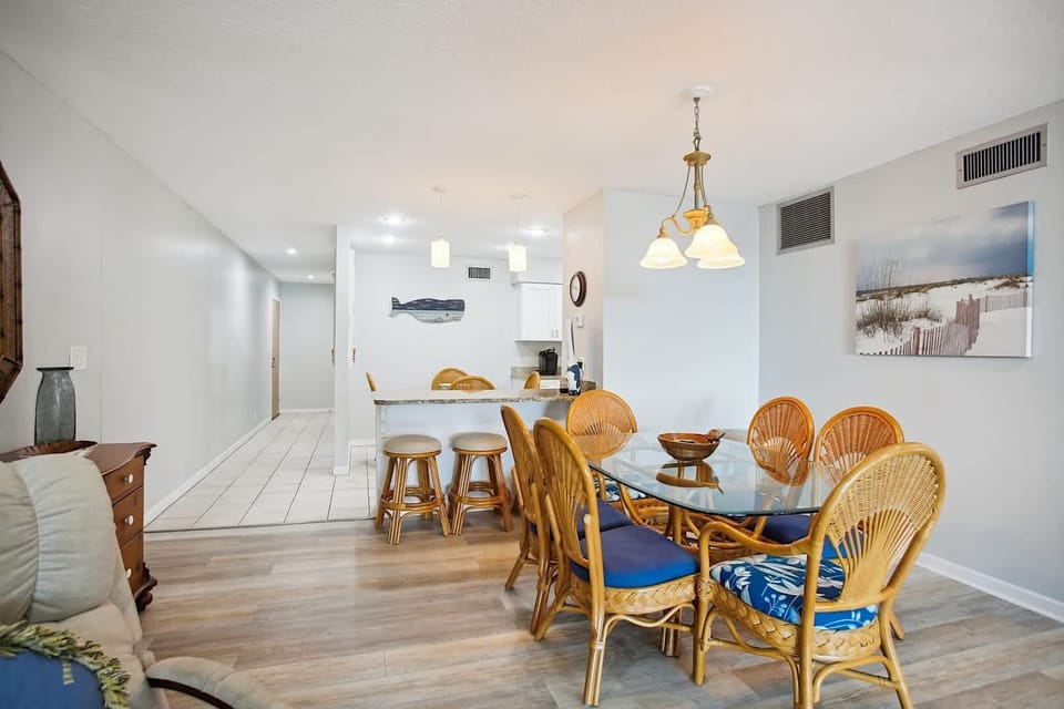 - Elegant dining space with glass top table and rattan chairs for family meals
- Bar seating nearby allows for flexible dining and entertaining options
- Open floor plan keeps the flow between kitchen, dining, and living areas