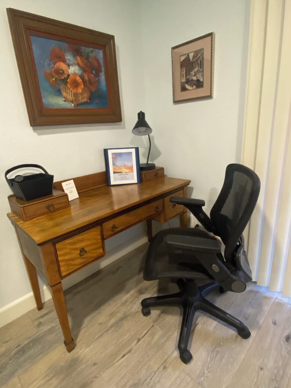 Petite work desk with ergonomic rolling chair.