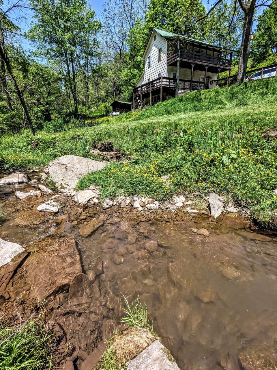 View of the house from the creek. Fire pit area is visible on lower left.