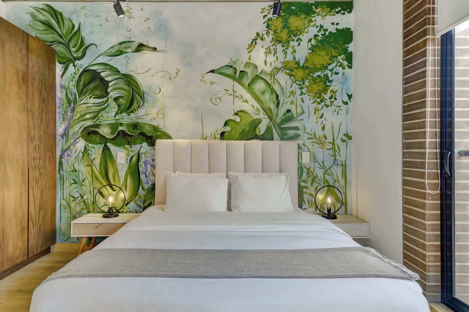 Comfortable bed surrounded by beautiful greenery-inspired décor.