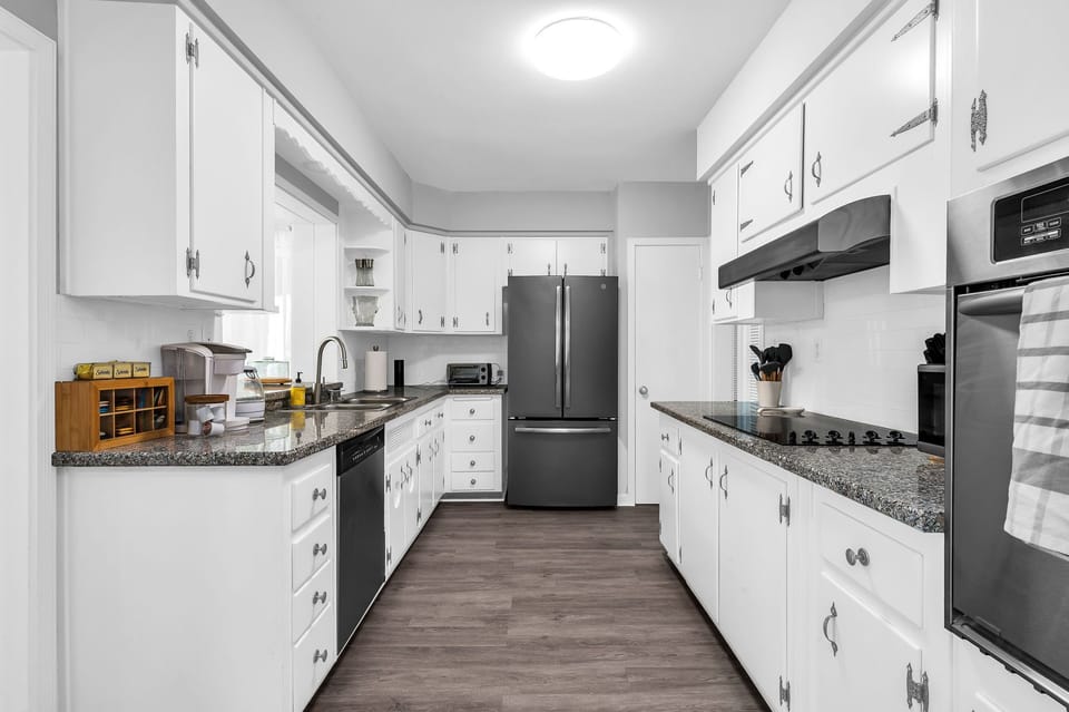 The kitchen has a unique antique feel with the original cabinetry. Upgraded with new flooring and black granite countertops. Fully equipped with everything you need to create a lovely meal for friends and family.