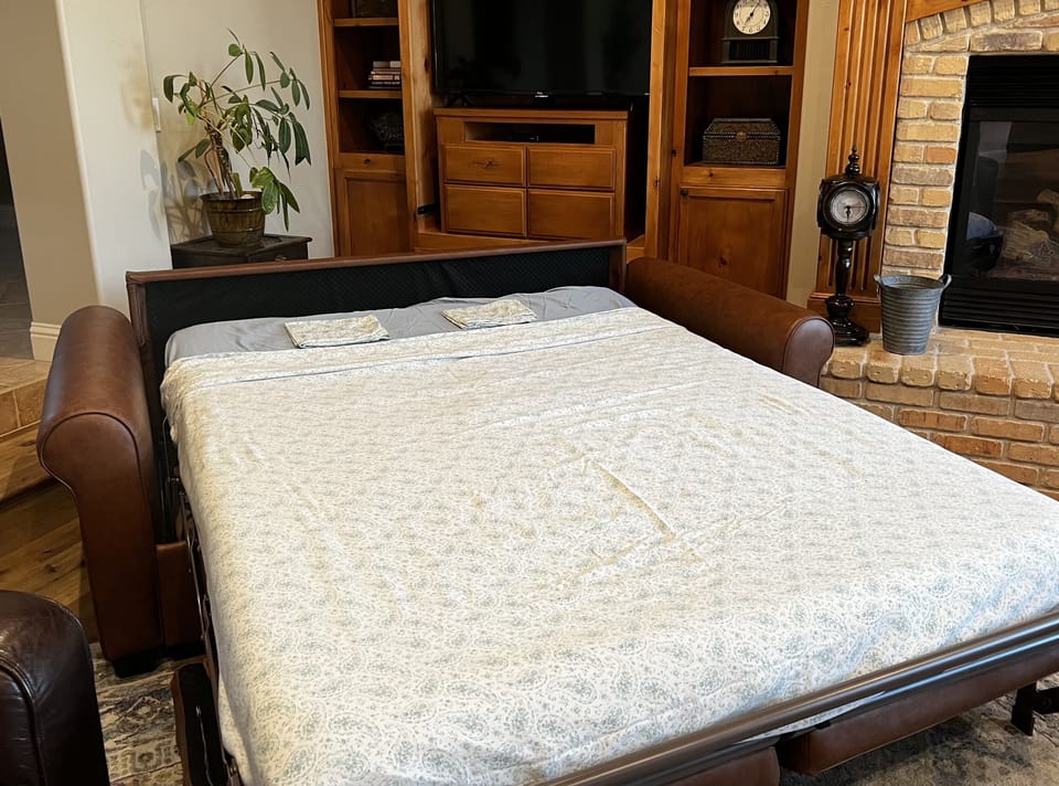 Full sized bed for two in this sofa bed located in living room.