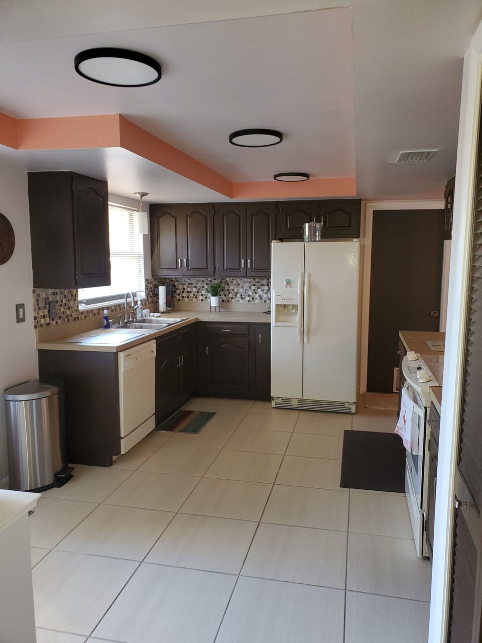 Kitchen has cooking and serving tools, appliances, spices, towels, cleaning prod