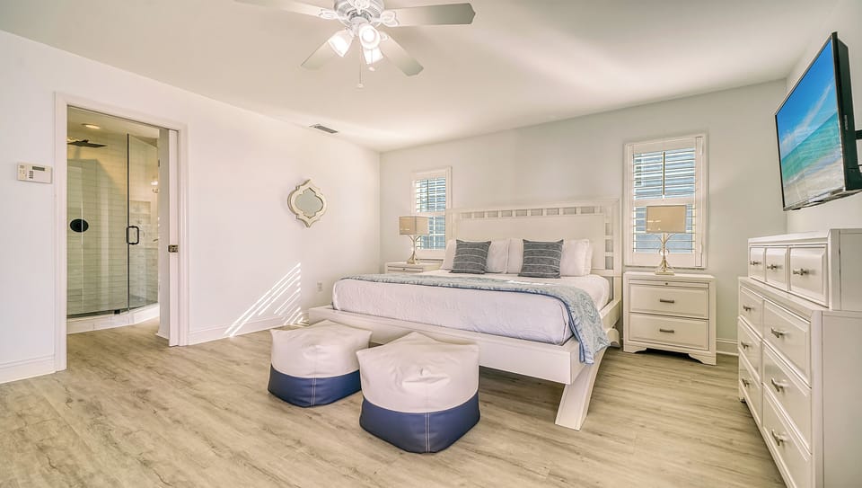Bedroom 2 boasts a king bed, abundant natural light, and a private balcony overlooking the pool, creating a serene retreat for morning coffee or evening relaxation.