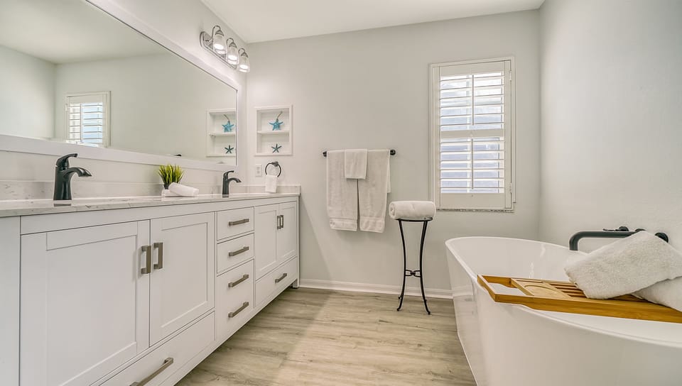 Bedroom 2 ensuite bath with double vanity and euro-style soaking tub inviting a deep, relaxing soak.
