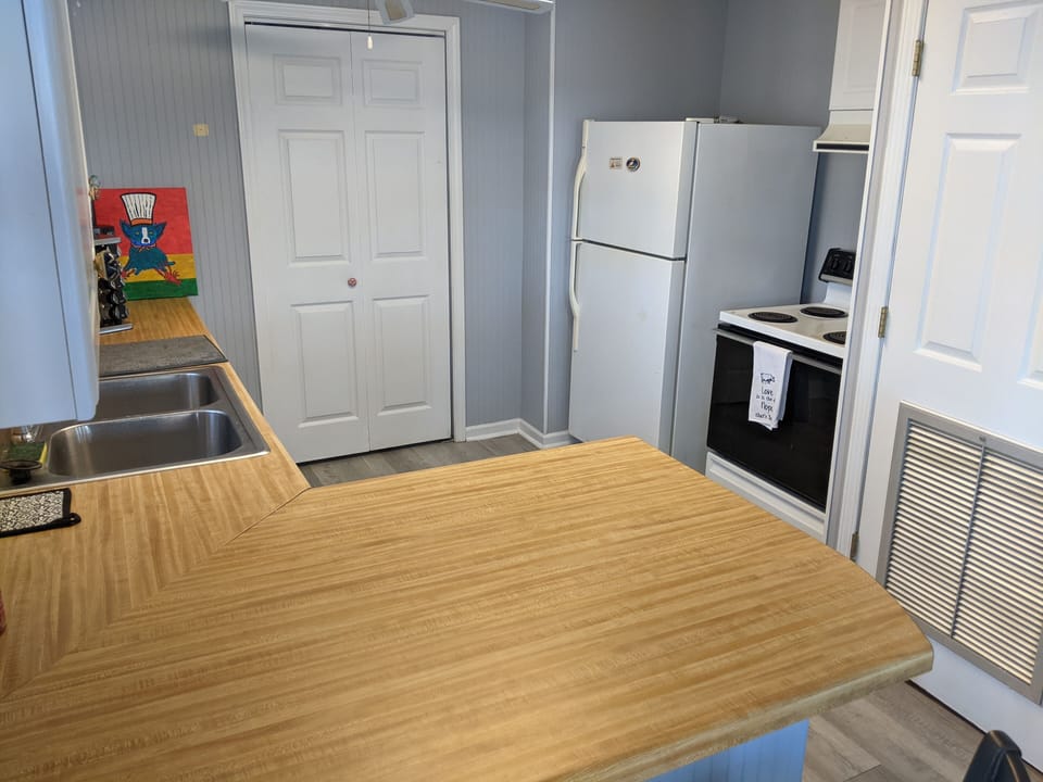 Kitchen w/ fridge/freezer, coffee pot, dishwasher, 2 bar  stools, eat in area.