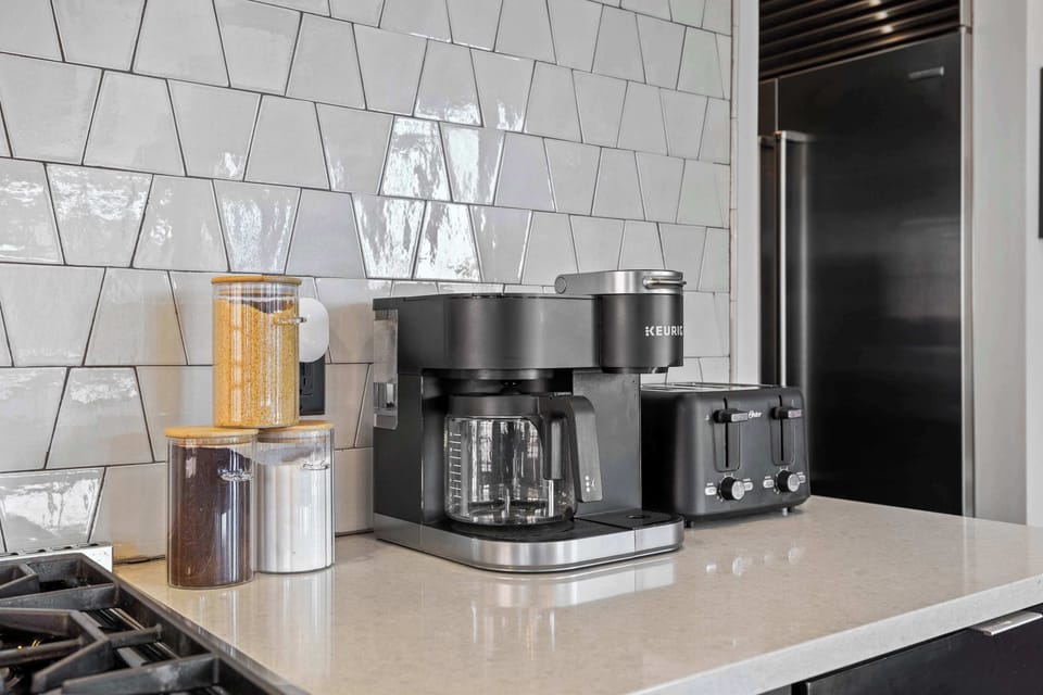 Fully equipped chef's kitchen featuring high-end Wolf and Sub-Zero appliances, a large island with bar seating, and a coffee station for your daily caffeine fix.
