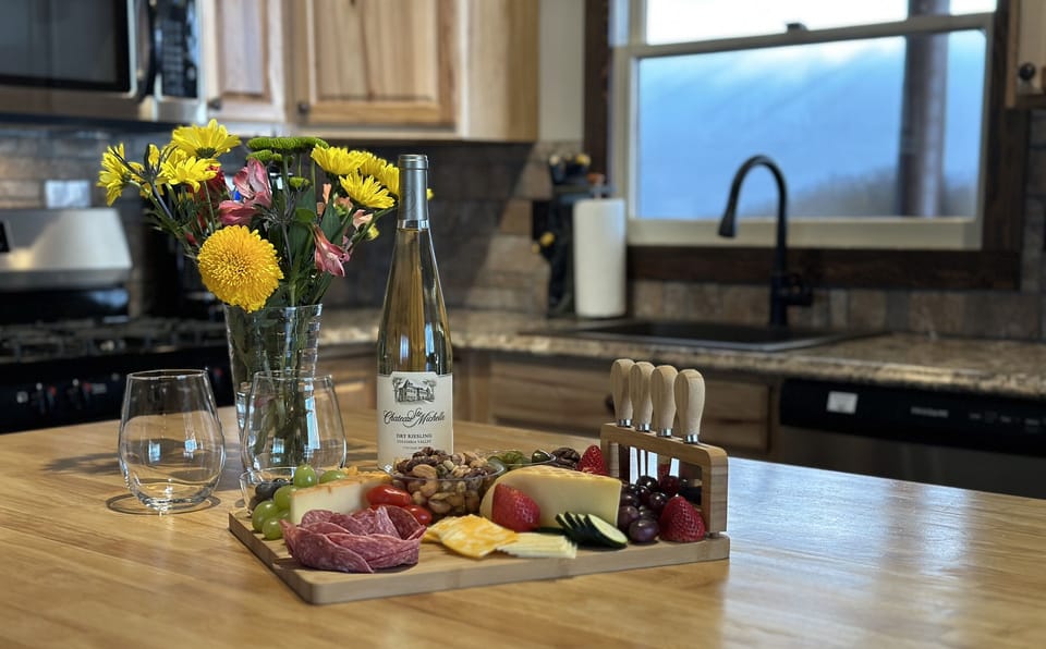 Find a generous assortment of spices, oils, quality cookware and appliances, charcuterie board, crock pot, etc. in the fully-stocked kitchen.
