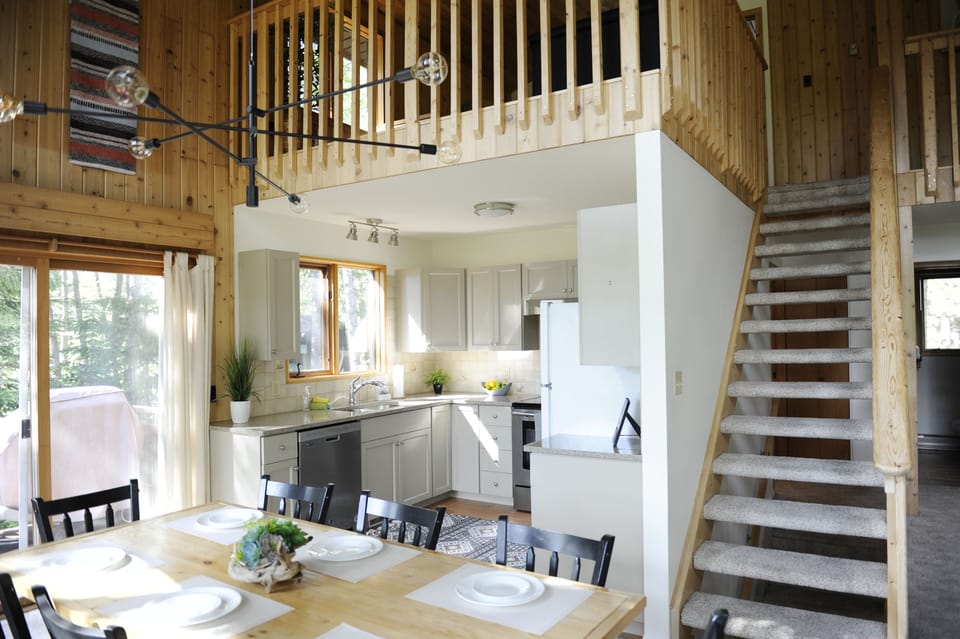 Bright, clean kitchen open to dining area with BBQ right outside
