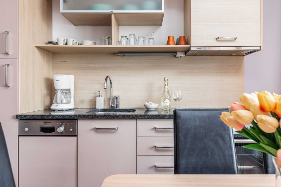 Close-up view of kitchen cabinets and appliances, with a small bouquet of flowers on the table.