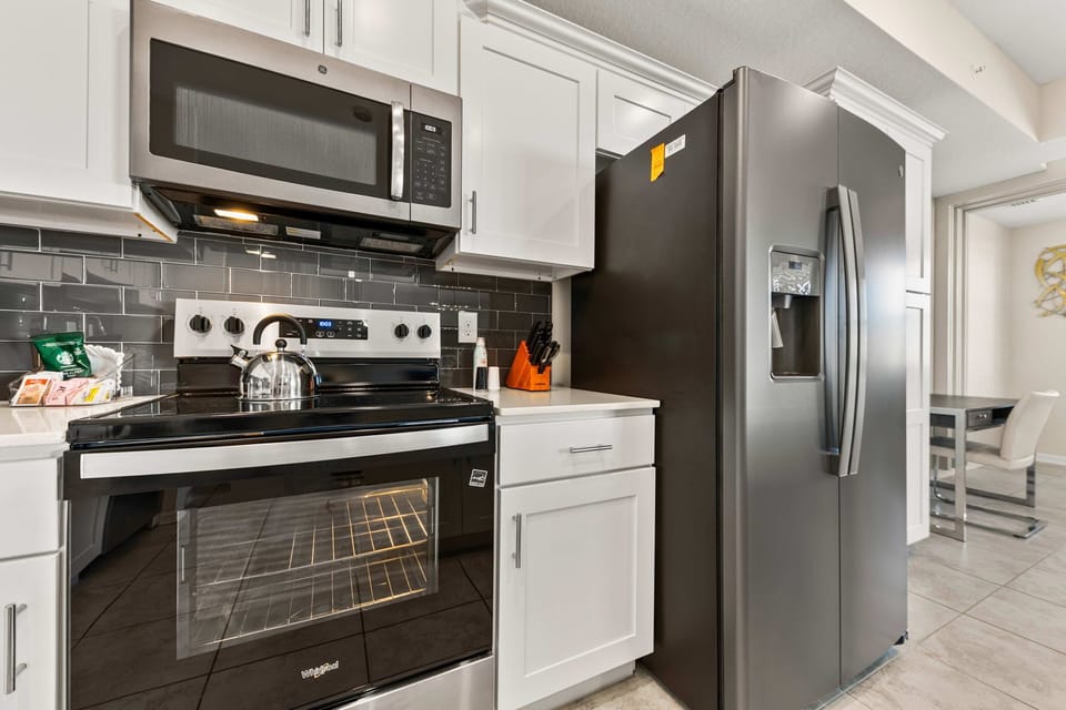 Well-Designed Kitchen of the condo in Kissimmee Florida - Integrated appliances for a seamless and stylish appearance - Thoughtful placement of kitchen essentials for easy access - Breakfast bar and high chairs
