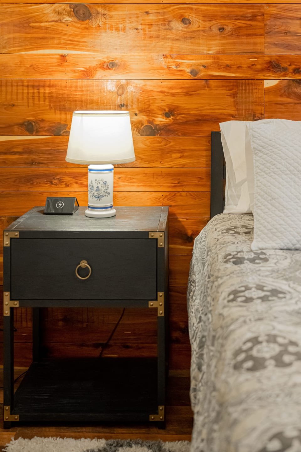 The secondary bedroom has a charging station next to bed.
