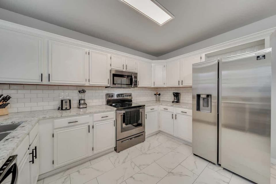 Cook with ease in this bright, stylish kitchen, featuring a stove, oven, refrigerator, coffee maker, and all essential cookware.
