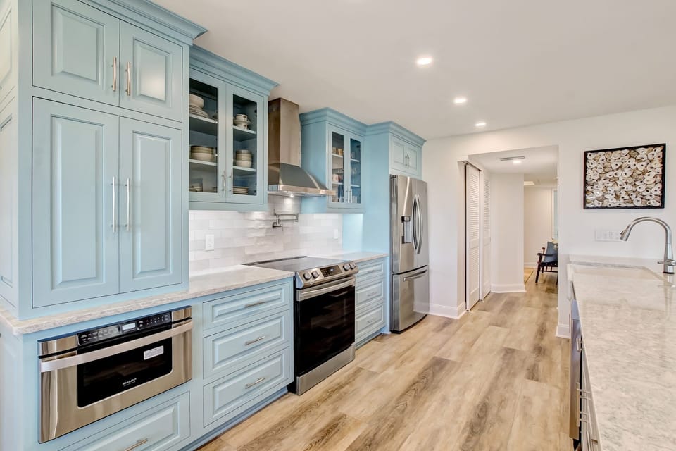 Luxury Chef's Kitchen with Quartz Countertops, Designer Cabinetry, a Farmhouse Sink, Stainless Steel Appliances, and Barstool Seating for 6