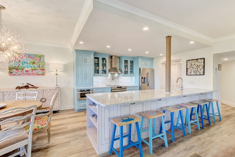 Luxury Chef's Kitchen with Quartz Countertops, Designer Cabinetry, a Farmhouse Sink, Stainless Steel Appliances, and Barstool Seating for 6
