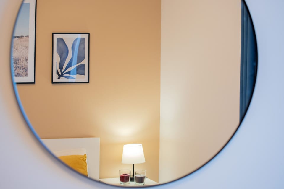 A stylish round mirror with soft lighting in the hallway or bathroom.
