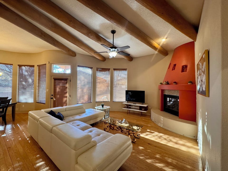 Living room area with vaulted ceilings, gas fireplace and beautiful wood beams.