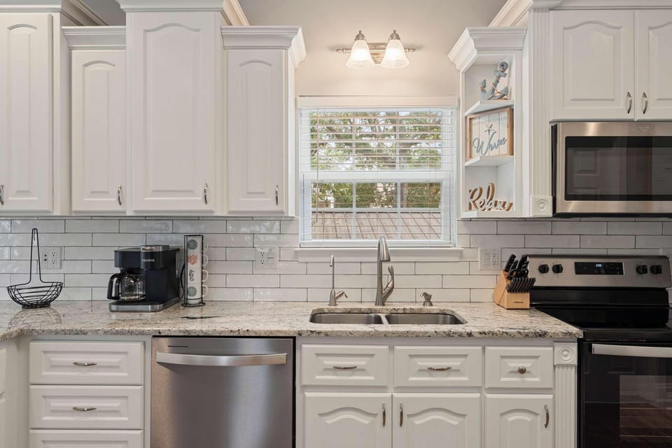 Bright, modern kitchen with stainless steel appliances and cozy window view