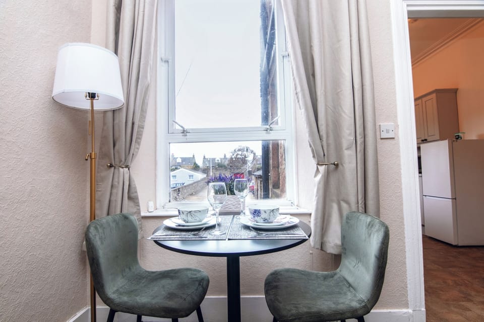 Elegant dining setup by the window with natural light — perfect for a relaxed breakfast or evening meal during your stay.