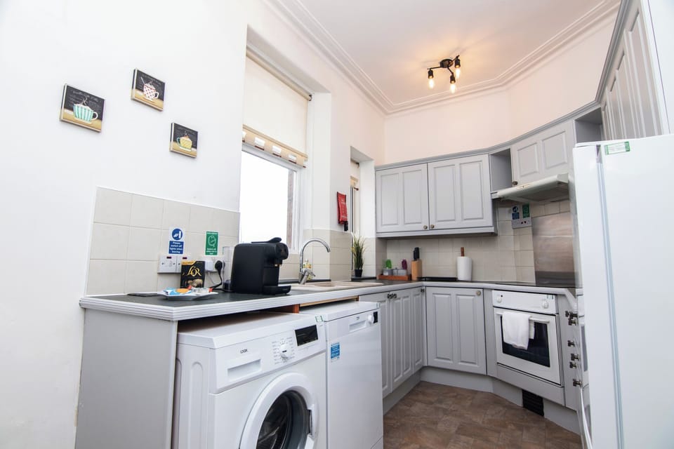 Light-filled kitchen with integrated washing machine and dishwasher — practical and well suited to extended stays. 